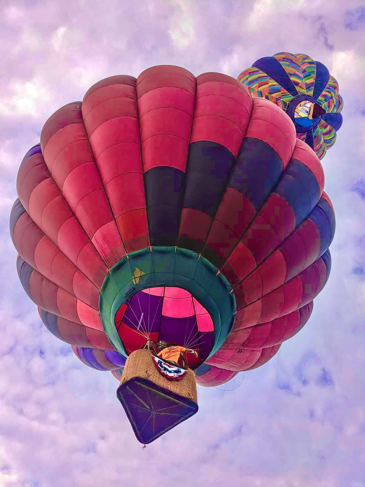Balloon drifting through a pink and purple sky