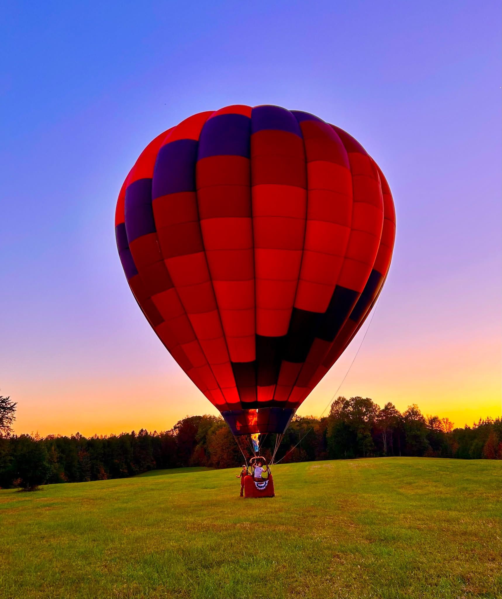 Balloon standing tall in a field at sunset