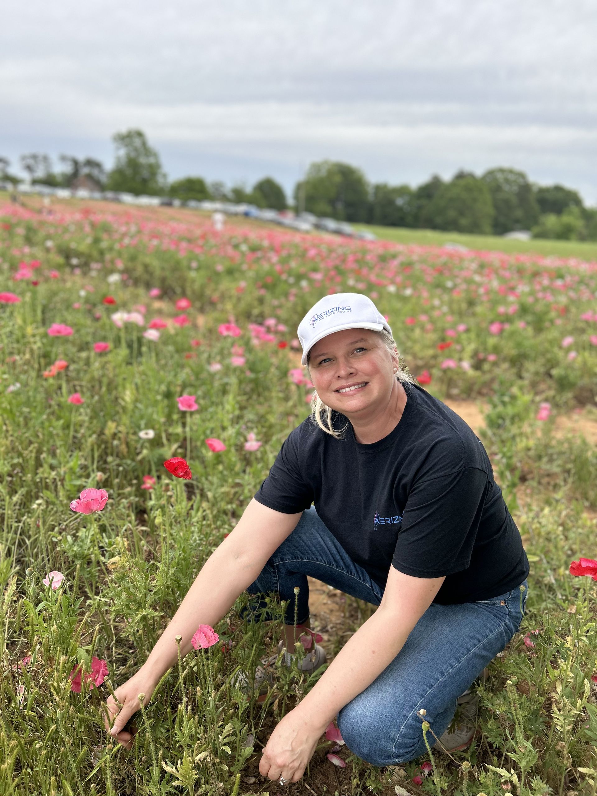 A guest kneeling in a field of poppies