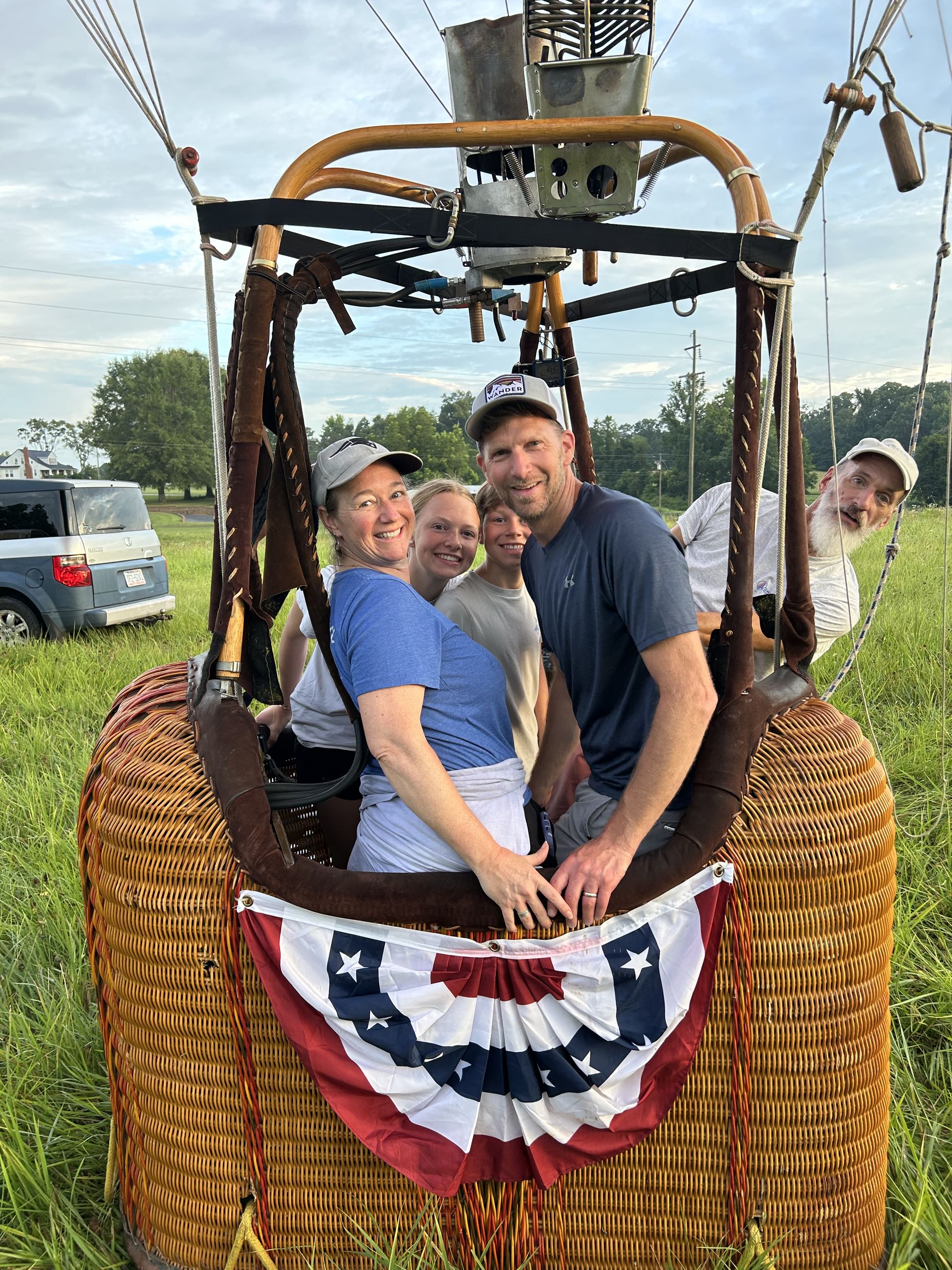 Passengers smiling in the balloon basket mid-flight